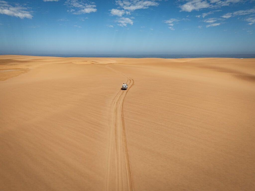 a 4x4 driving in the coastal dunes of Iona National Park. Vast and empty.